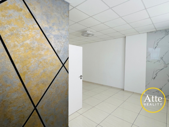 Interior showroom scene featuring a large textured wall panel in gold and blue with black diagonal lines, a white door, and tiled floor.