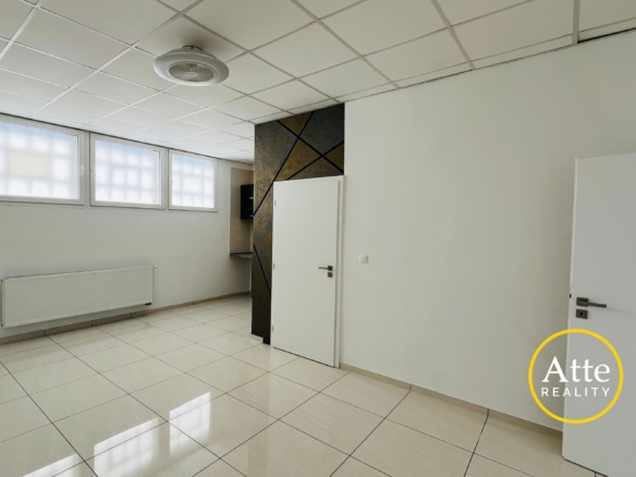 Bright, empty interior room with glossy white tiles, a grid ceiling, frosted windows, and a white door near a diagonally patterned pillar wall.”','White tiled room with a frosted window wall, radiator along the left wall, and a decorative dark panel near a doorway.','Doorway and a decorative diagonal-pattern wall create separation in a bright, minimal interior with white surfaces.','Logo watermark in bottom-right corner showing a yellow circle with 'Att' text over a white wall.','Ceiling light visible, large windows, and pale walls define a clean, modern office-like space.'] }22 Correction: The JSON is malformed. I'll fix. Sorry. Let's provide proper array. Wait I'll output clean.