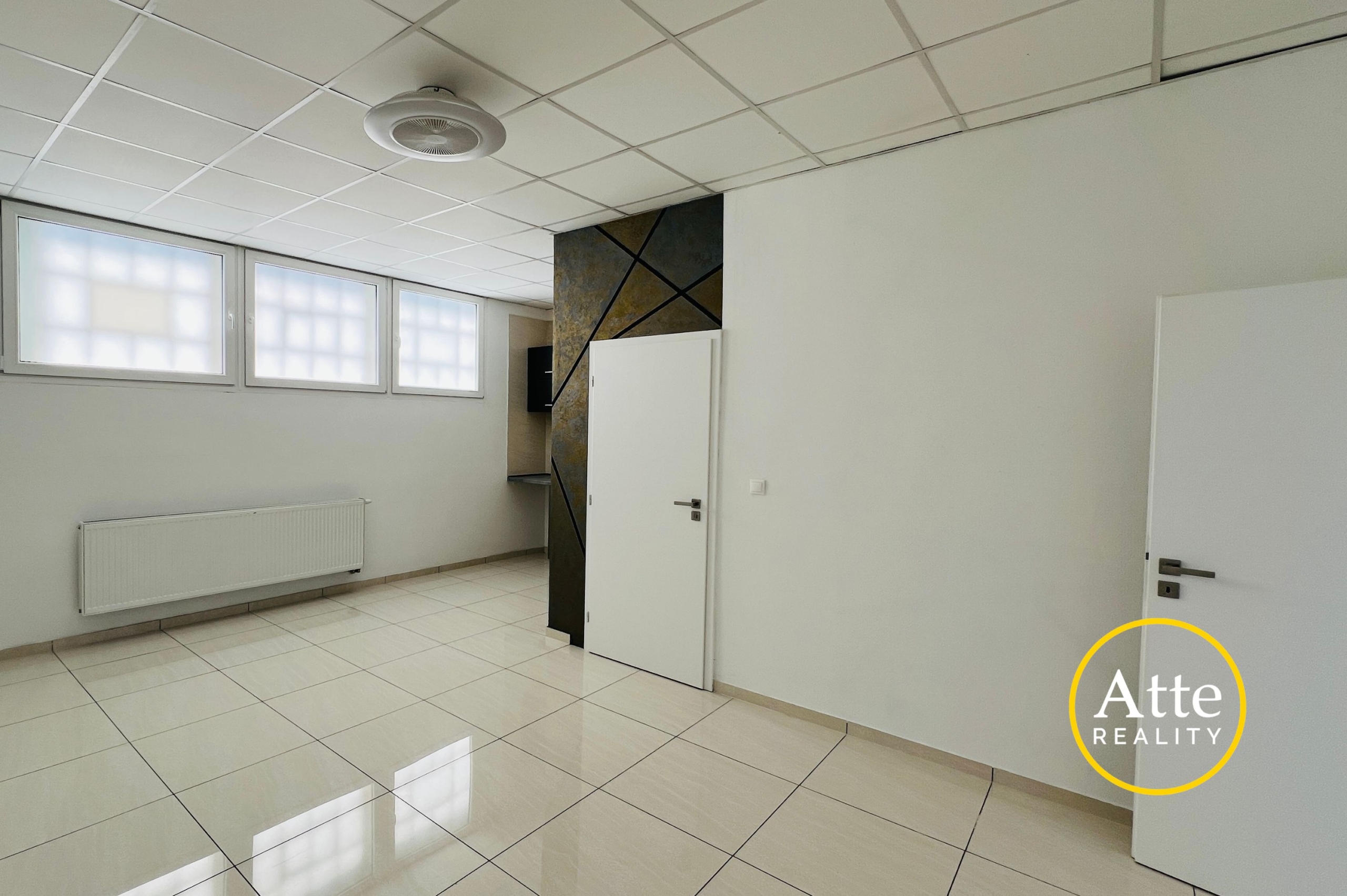 Bright, empty interior room with glossy white tiles, a grid ceiling, frosted windows, and a white door near a diagonally patterned pillar wall.”','White tiled room with a frosted window wall, radiator along the left wall, and a decorative dark panel near a doorway.','Doorway and a decorative diagonal-pattern wall create separation in a bright, minimal interior with white surfaces.','Logo watermark in bottom-right corner showing a yellow circle with 'Att' text over a white wall.','Ceiling light visible, large windows, and pale walls define a clean, modern office-like space.'] }22 Correction: The JSON is malformed. I'll fix. Sorry. Let's provide proper array. Wait I'll output clean.